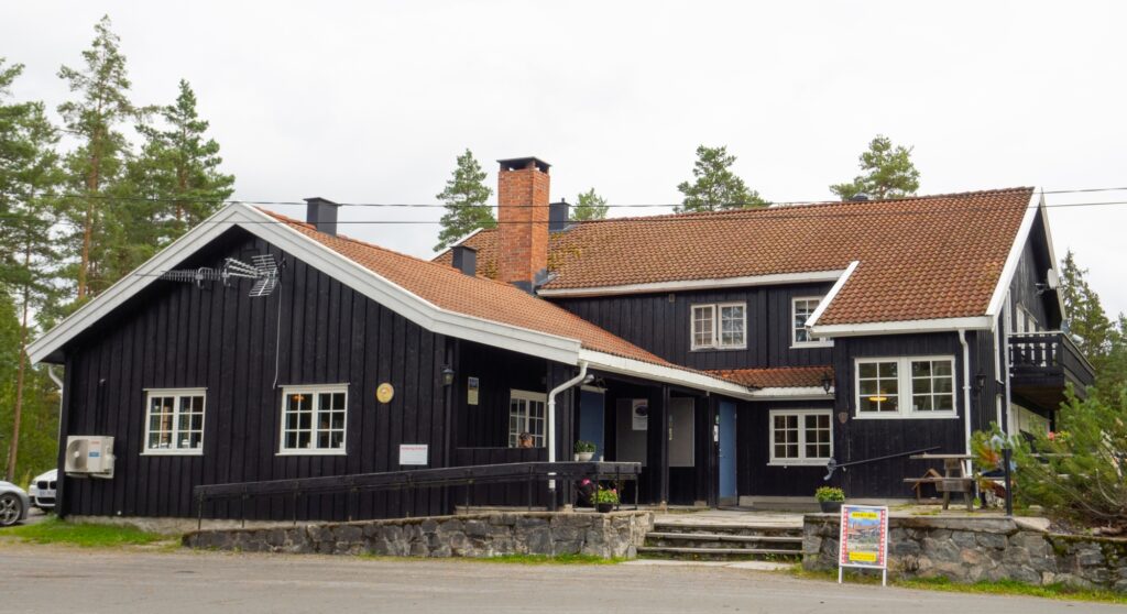 Hele Dragsjøhytta en høst dag, med trær i bakgrunnen. Lokasjon for Nes kunstforenings framvisning av Romeriksutstillingen.
